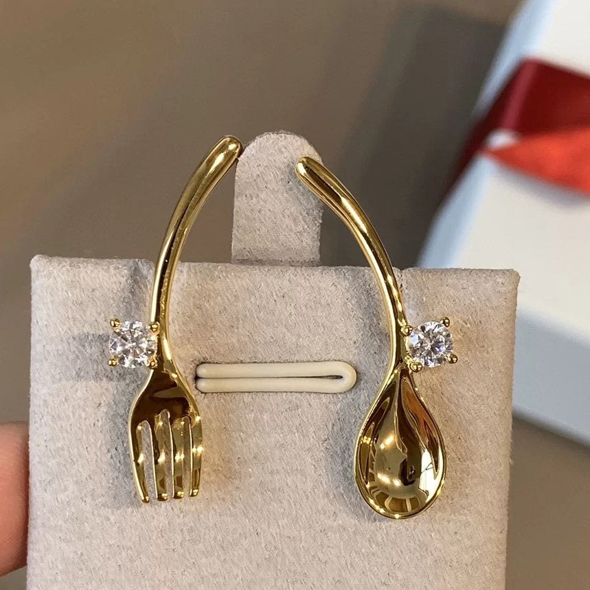 Golden cutlery and diamond earrings