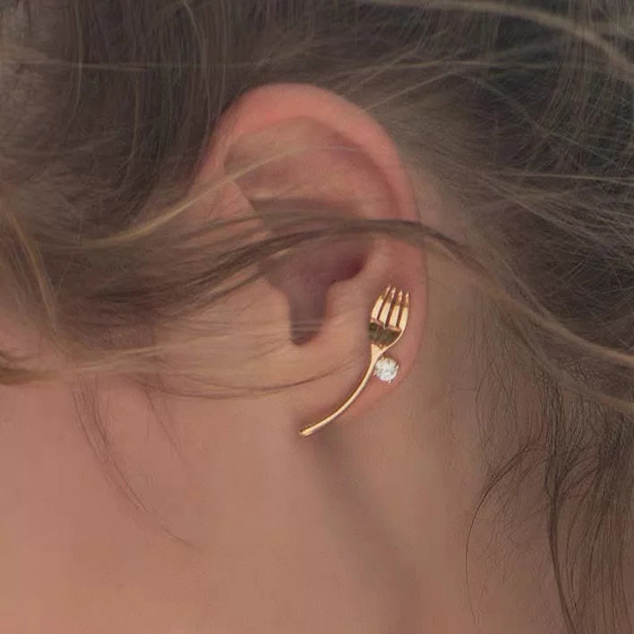 Golden cutlery and diamond earrings